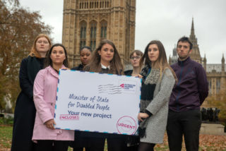 Campaigns team standing outside Westminster with a signed petition