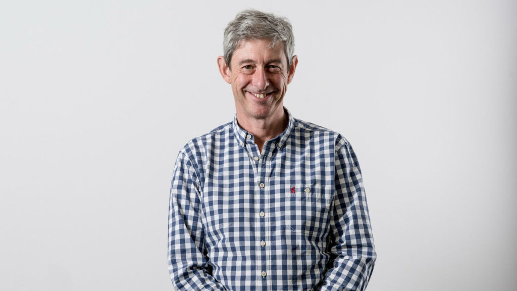 Richard wearing a check shirt and smiling