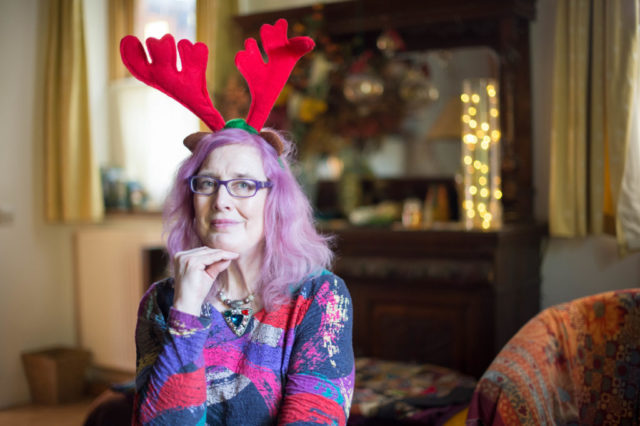 Kate has purple hear and is wearing Christmas reindeer antlers on her head.