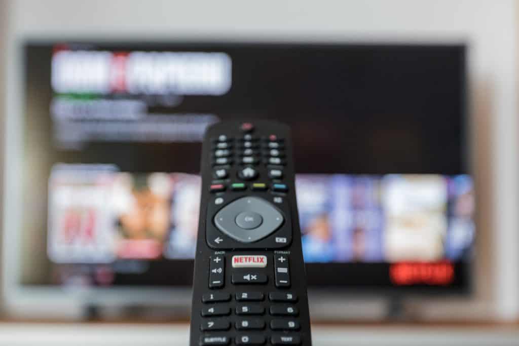 A remote control pointing at a television screen.
