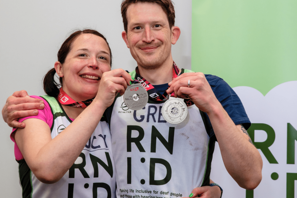 A picture of the woman with her brother, both holding medals and posing for the camera.