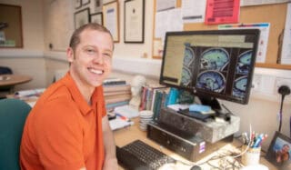 A researcher pictured in front of a computer