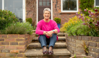 A woman pictured sitting on a step outside her house