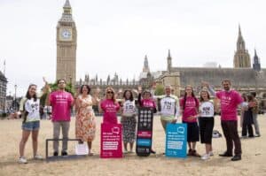 A group of campaigners with placards standing in front of the Houses of Parliament and Big Ben.