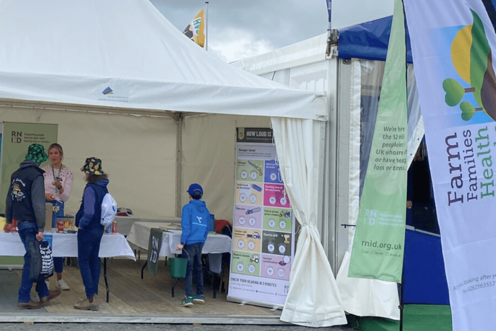 A RNID volunteer speaking with visitors at the Balmoral Show. 
