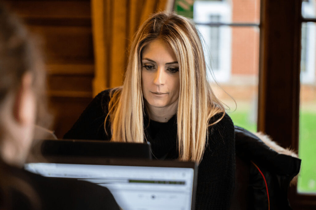 A woman sitting at a desk using a laptop.