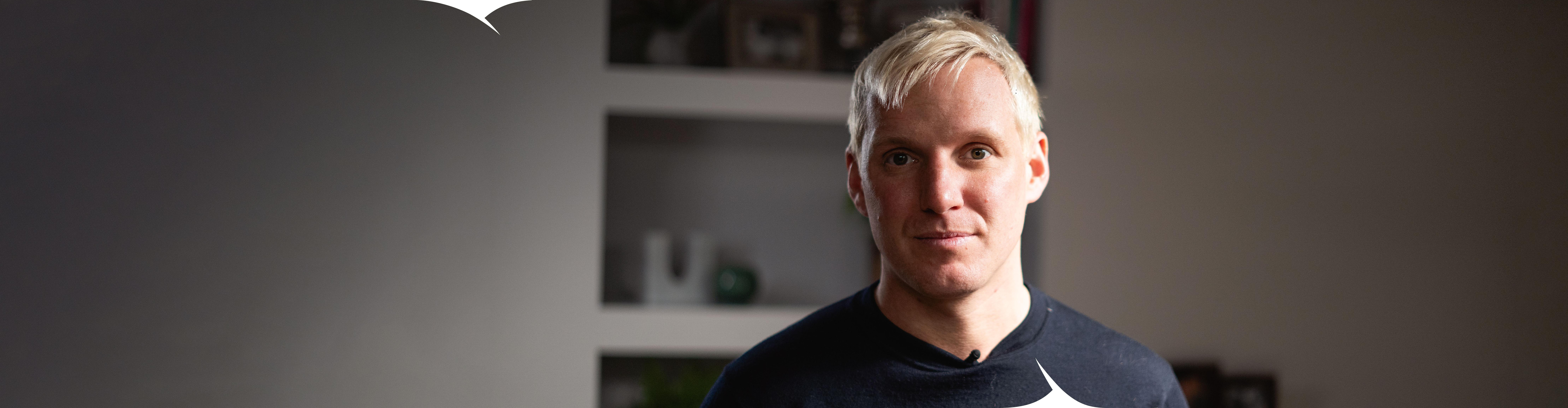 TV personality Jamie Laing. A man with blond hair looks at the camera, standing in his living room. 