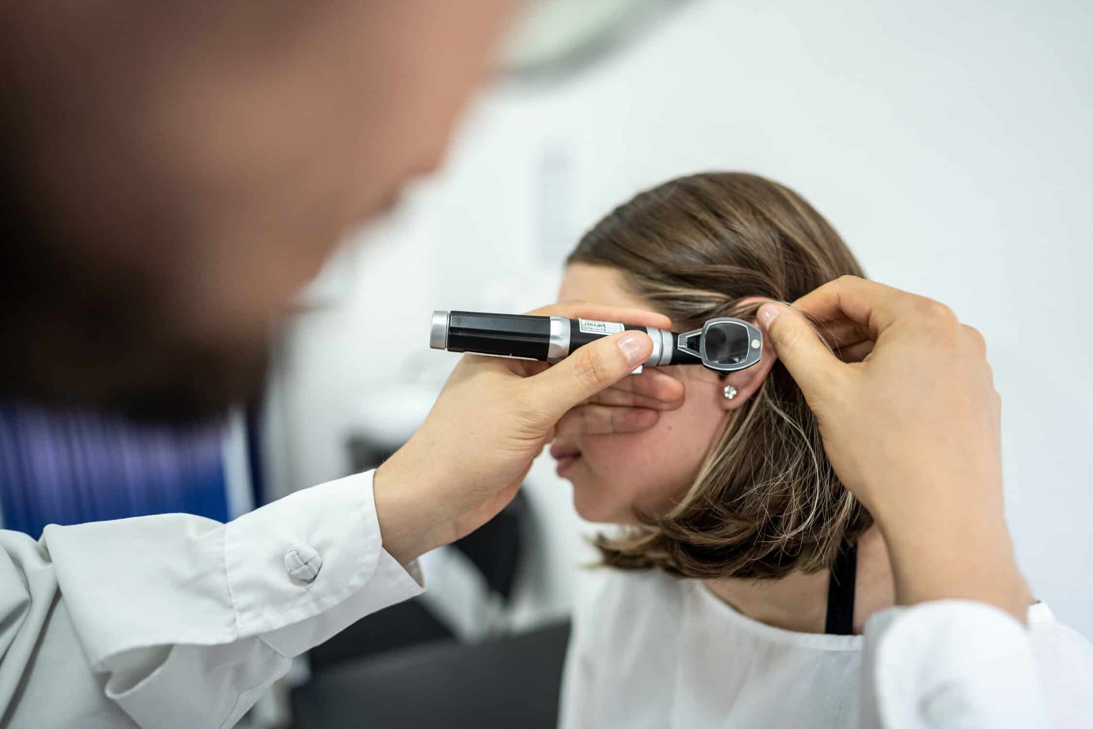 An audiologist looking into a patient's ear