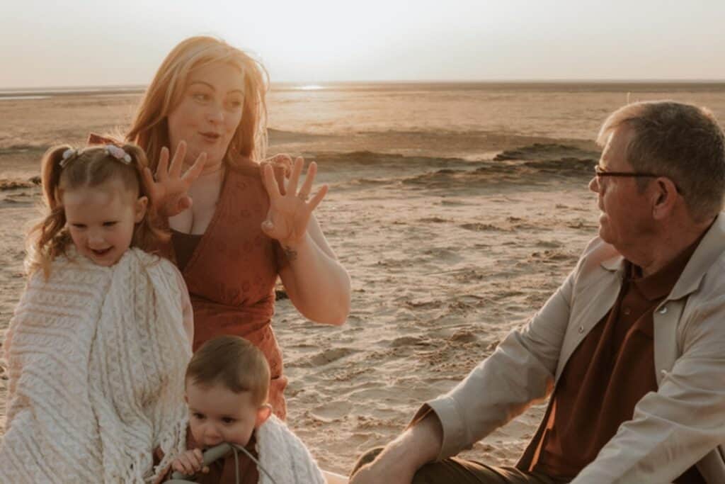 Kate and her family on the beach at sunset