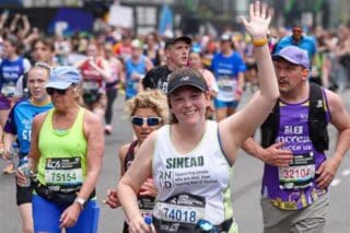 RNID Director of Fundraising, Sinéad Donoghue, waves to the camera as she runs in the London Marathon.