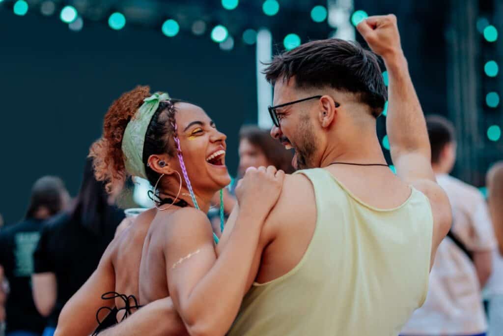Two people dancing at a festival wearing hearing protection