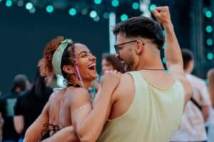 Two people dancing at a festival wearing hearing protection