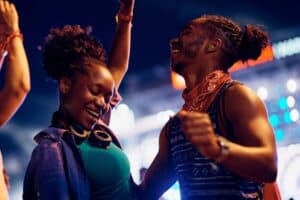 Two people dancing at a festival wearing hearing protection.