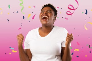 A woman celebrates with streamers and confetti in the air.