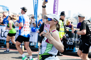 RNID runner in London marathon holding phone camera