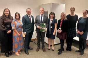 A group of people, including RNID representatives, stand together on the day the Welsh Government launches Future Approach to Audiology.