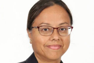 A headshot of researcher Paramita Baruah. She has brown hair and wears glasses.