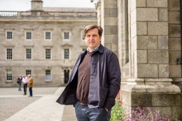Tinnitus researcher Sven Vanneste stands in a beautiful courtyard in a coat