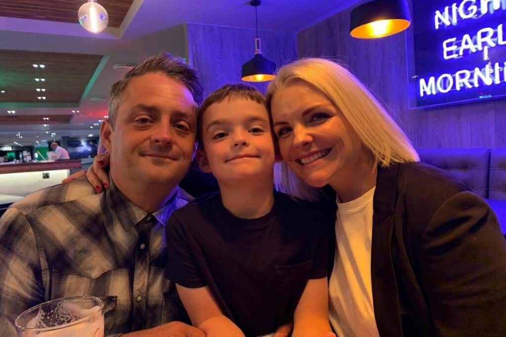 A smiling mum and dad with their child.