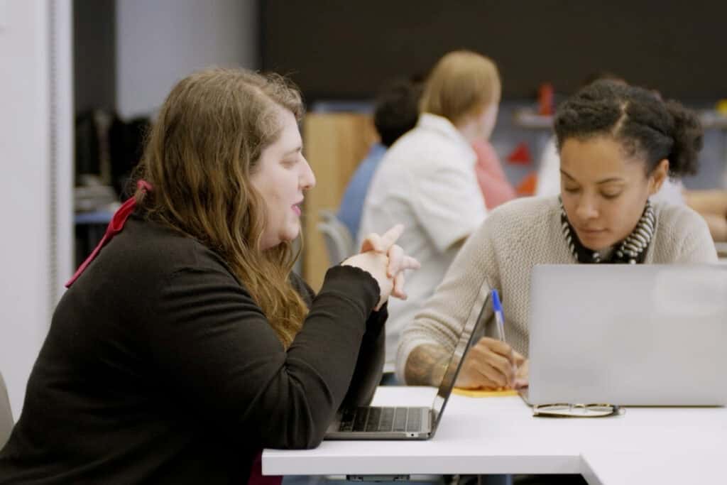 Facilitators at Meta's co-design sprint, sat together at a desk