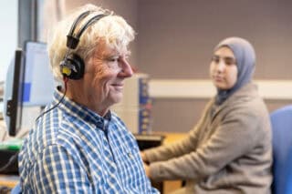 An elderly man wears headphones during a hearing check.
