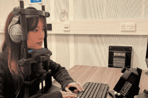 RNID researcher Xena uses eye tracking equipment in the laboratory.