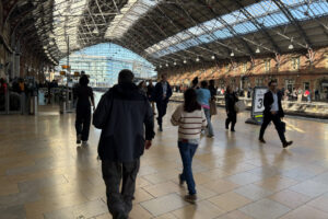 People walking along a train station platform