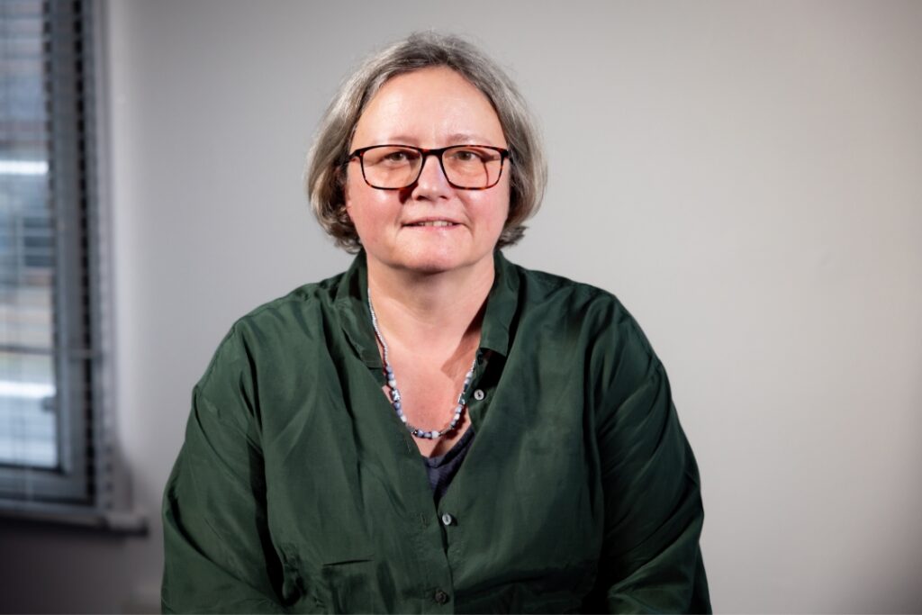Professor Sally Dawson wears glasses and a green shirt.
