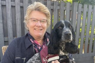 RNID storyteller Nicola sits outside with her hearing dog, Dolly
